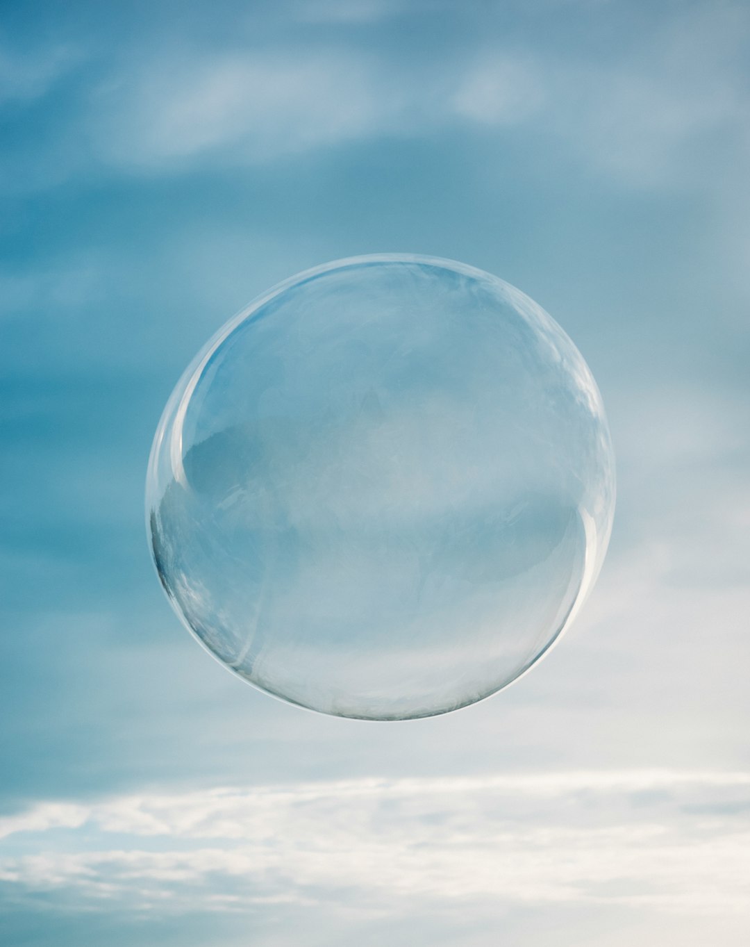 Photo by Dynamic Wang a clear bubble floating in the air on a cloudy day